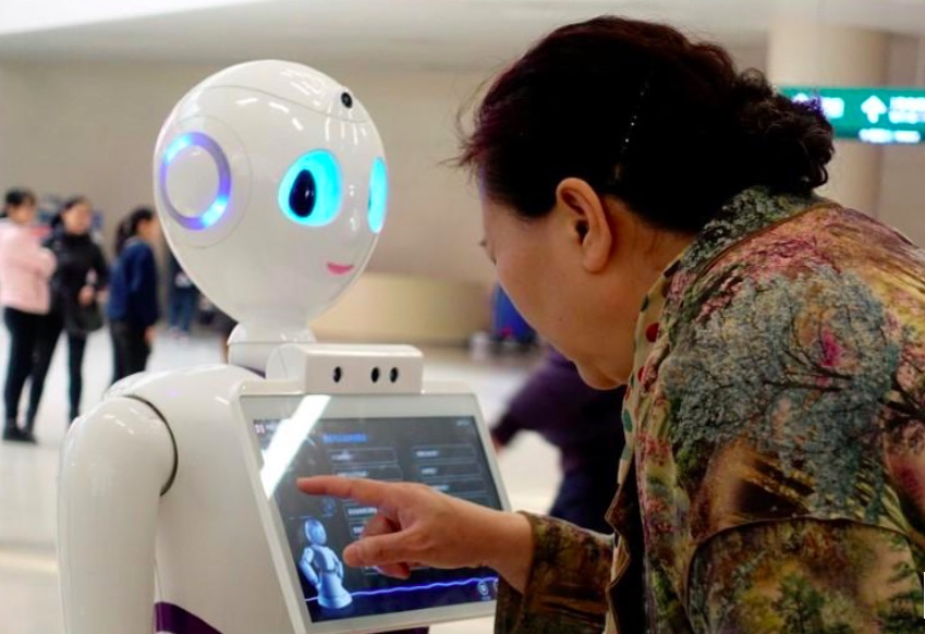 Người phụ nữ chạm vào màn hình trên robot do iFlytek phát triển tại phòng khám ở Bắc Kinh, Trung Quốc. Ảnh: Reuters